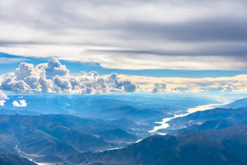 Aerial view above the clouds and mountain peaks on a sunny day.mountain view from airplane.