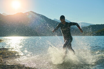 triathlon athlete starting swimming training on lake