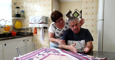 Troubled senior couple at home kitchen. Older married couple going through struggle - Powered by Adobe