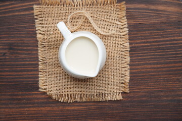 A jug of fresh milk on an old wooden table