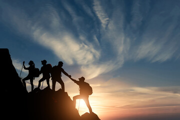 Silhouette male hiker groups celebrating success on top of a mountain in a majestic sunset and Two climber helping to hike up . Concept for success ,help, teamwork and Leadership concept . - obrazy, fototapety, plakaty