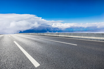 Empty asphalt road and blue sky with white clouds scenery.