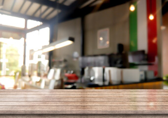 Empty wooden table top with lights bokeh on blur coffee shop background.
