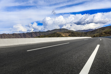 Asphalt road and mountain with sky clouds landscape.