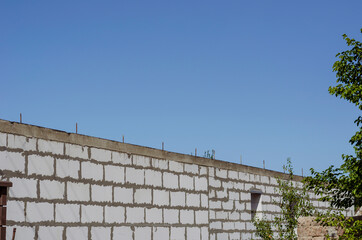 Stone wall with concrete and fittings against the blue sky.