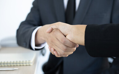 Employee wearing a black suit shaking hands