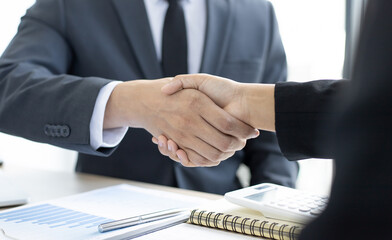 Employee wearing a black suit shaking hands