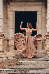 young beautiful girl in a silk dress in an old manor