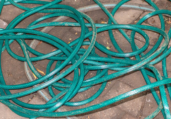 A tangled hose pipe isolated on a paved surface