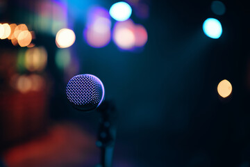 Stage and retro microphone. Microphone on the stand for public speaking, welcoming or congratulations speech. Abstract blurred background.