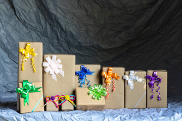 Numerous gift boxes tied with a bow inside a gray canvas.