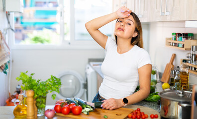 Unhappy mexican housewoman crying during cooking at kitchen