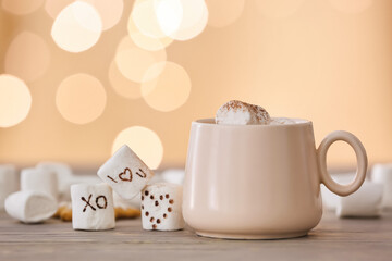 Cup of tasty cocoa drink with marshmallows on table