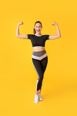 Fototapeta na wymiar Happy sporty young woman on color background. Concept of goal achievement