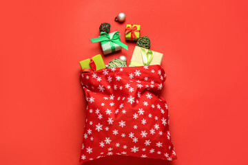 Santa bag with gifts on color background