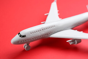 Toy airplane on red background, closeup view