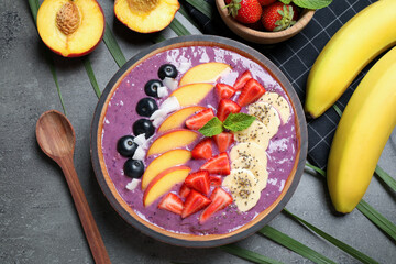 Delicious acai smoothie with fruits served on grey table, flat lay