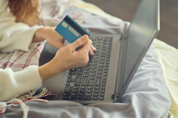 Close-up woman's hands holding a credit card and using computer keyboard for online shopping