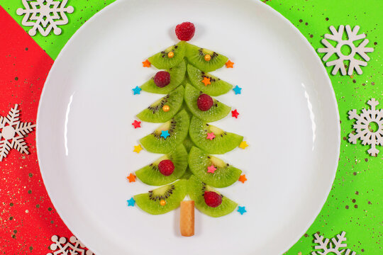 Christmas tree made of kiwi slices on winter color table.