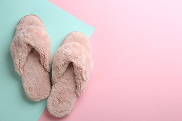 Pair of stylish soft slippers on color background, flat lay. Space for text