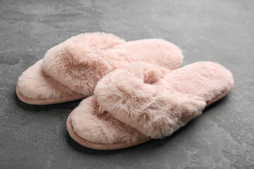 Pair of stylish soft slippers on grey background