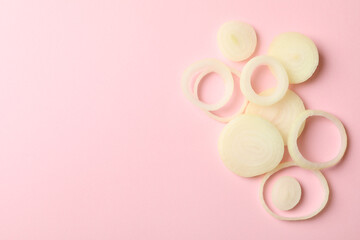 Fresh onion slices on pink background, top view