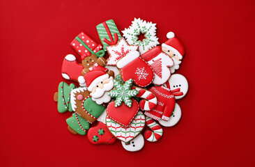 Different Christmas gingerbread cookies on red background, flat lay