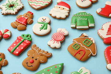 Different Christmas gingerbread cookies on light blue background, closeup