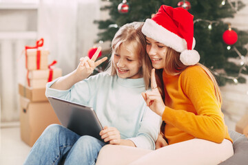 Two teenage girls with blonde European looks chat with friends and grandparents on Christmas Day. Social distancing on New Year's Eve.