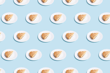 pattern of apple pie slices on white plate on blue background. trendy food pattern with shadow