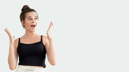 Great idea. Omg face. Excited pretty woman in black sleeveless top feeling amazed holding hands up...