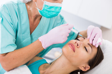 Portrait of woman during beauty facial injections in medical esthetic office
