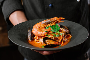 A dish of pasta with vegetables and big king shrimp