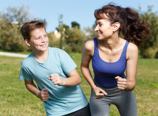 Mother and teen boy jogging during morning fitness workout