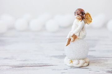 Ceramic figure of angel on light background. Copy spase.
