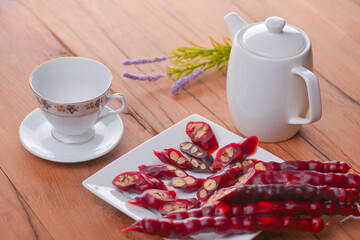 Tasty oriental sweets. Caucasian delicacy churchkhela - georgian nut treats. Served with a glass of tea and a tea pot.