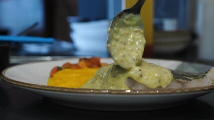 Cooking kitchen work area spoon mustard sauce over yellow pumpkin puree cod finishing touches before serving waiter Gastronomy food design Working conditions weekend full boarding loading many orders