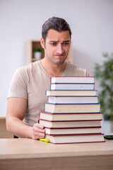 Young male student preparing for exams at library