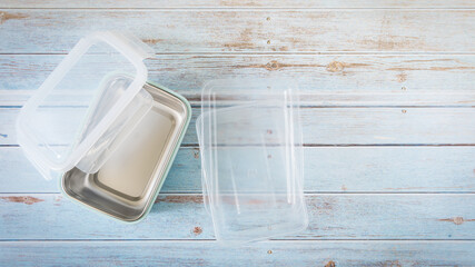 Fototapeta na wymiar Eco-friendly sustainable lifestyle. Top view of a washable lunch box beside a one-time use plastic food container. Daily waste, Awareness, Recycle, Biodegradable plastic, Disposable product.