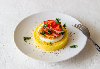 Polenta with mozzarella, bacon and tomatoes. Italian cuisine. Recipe.