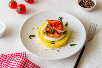 Polenta with mozzarella, bacon and tomatoes. Italian cuisine. Recipe.