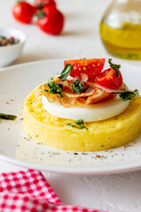 Polenta with mozzarella, bacon and tomatoes. Italian cuisine. Recipe.