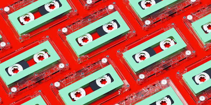 Minimal creative background for Christmas retro concept. Clear cassette tape with green label on red background. 3d rendering illustration. Clipping path of each element included.