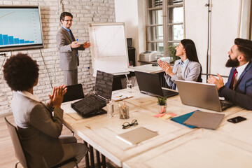 Senior businessman leading meeting at boardroom table.