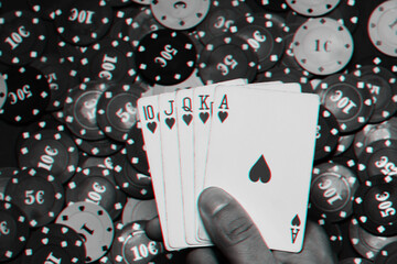 Royal flush in the hands of the player on the background of game chips