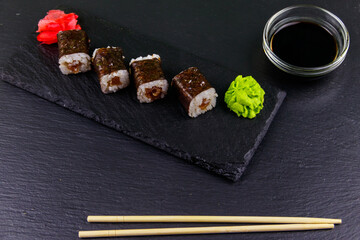 Sushi maki rolls with tuna on black slate