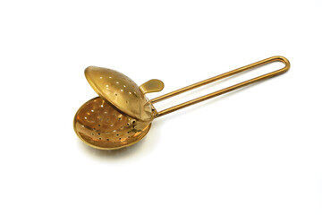 opened brass tea strainer or infuser isolated on white background    