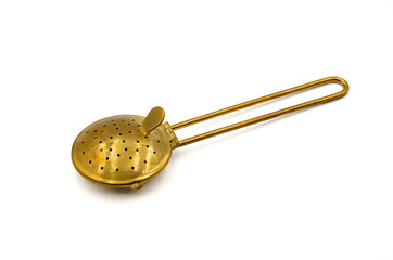brass tea strainer or infuser isolated on white background 
