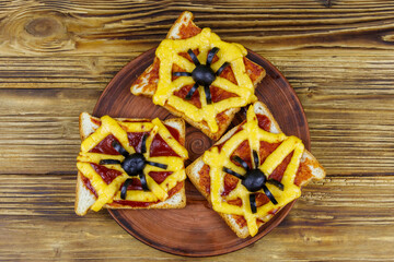 Funny sandwiches with spider and spider web for Halloween party on wooden table. Top view