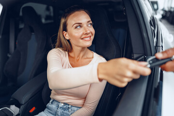 Fototapeta na wymiar Young attractive caucasian woman sits in her newly bought car